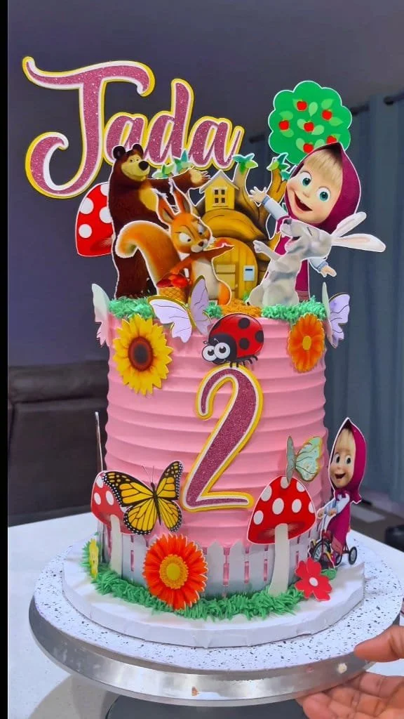 Masha and the Bear themed cake decorated with colorful characters and designs