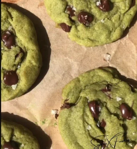 Freshly baked matcha chocolate chip cookies on a cooling rack.