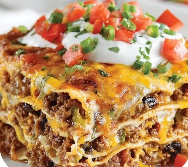 Delicious Mexican lasagna casserole topped with cheese and spices