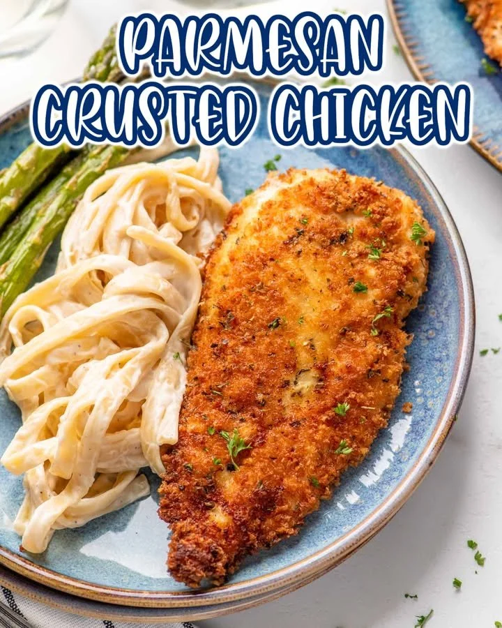 Plate of crispy Parmesan Crusted Chicken garnished with herbs