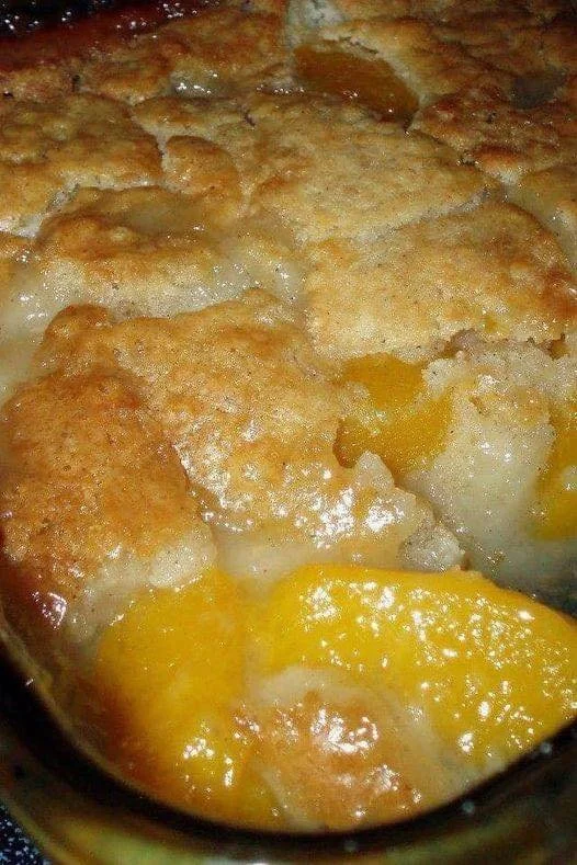 Warm homemade peach cobbler dessert served in a bowl