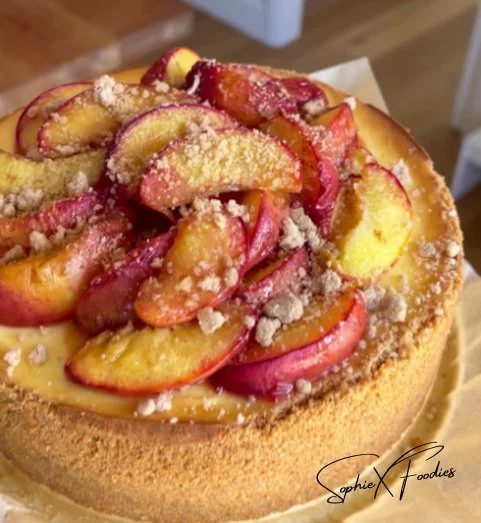 Delicious Peach Cobbler Cheesecake topped with fresh peaches and a buttery crust.