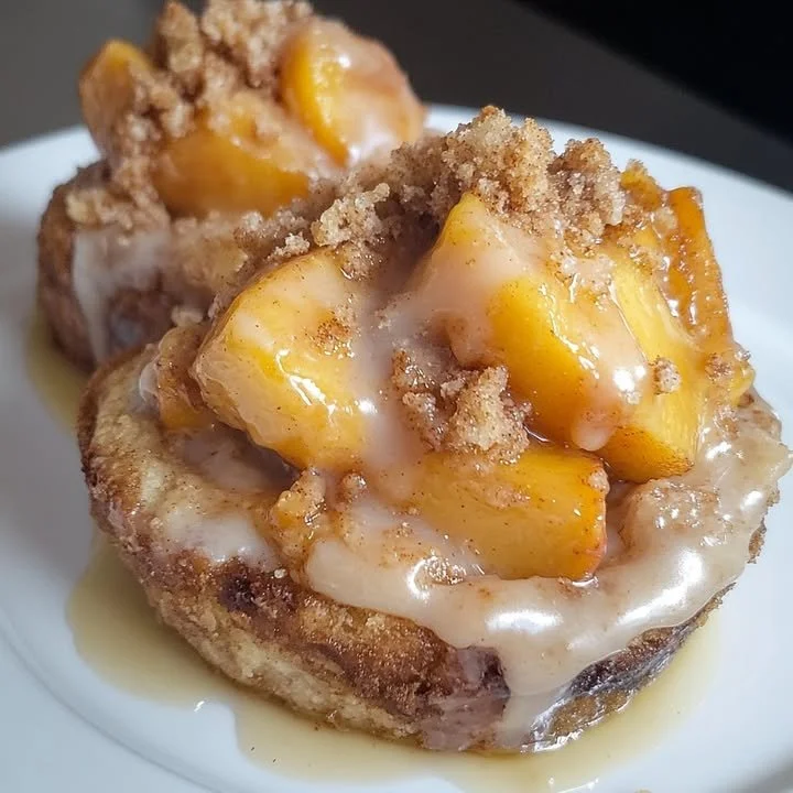 Delicious Peach Cobbler Cinnabites stacked on a plate with peach slices