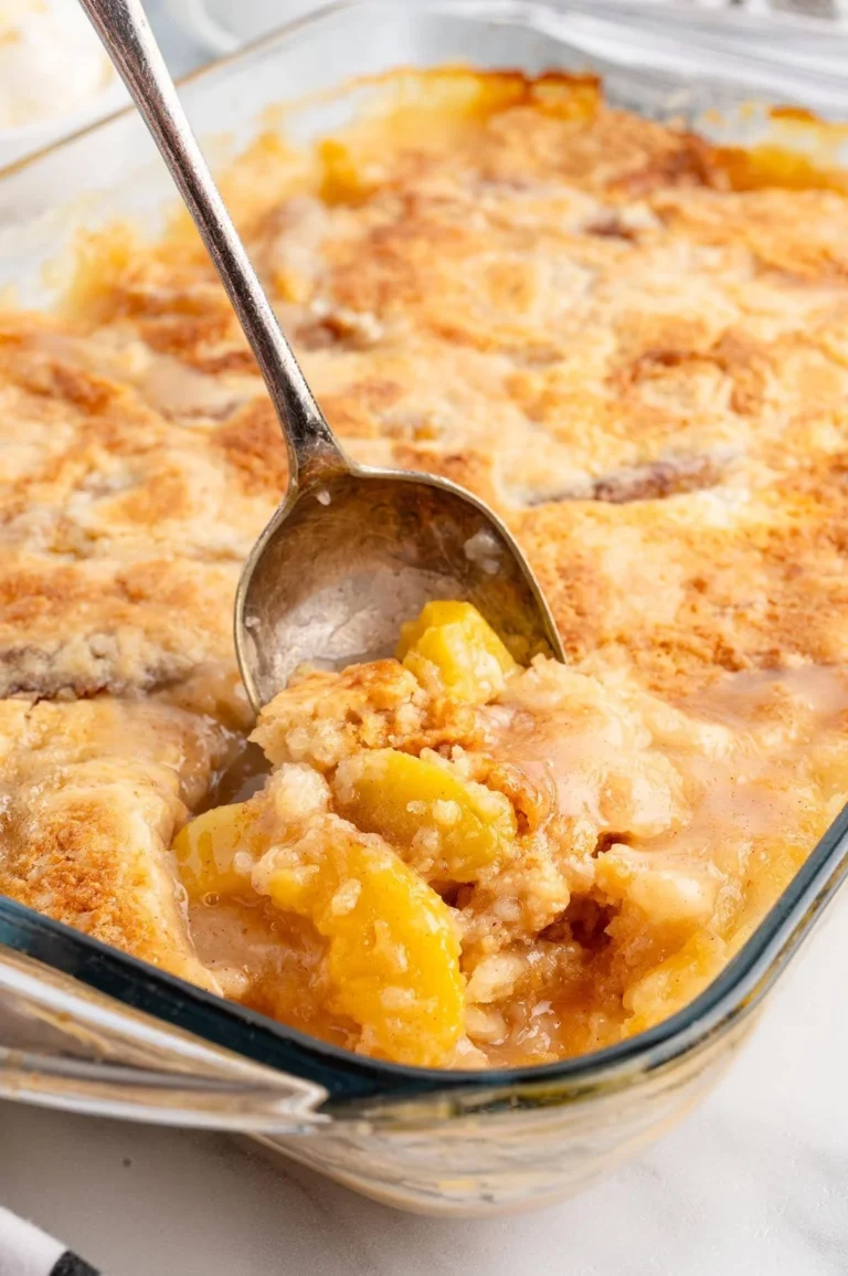 Delicious Peach Dump Cake topped with juicy peaches and crumbly goodness.
