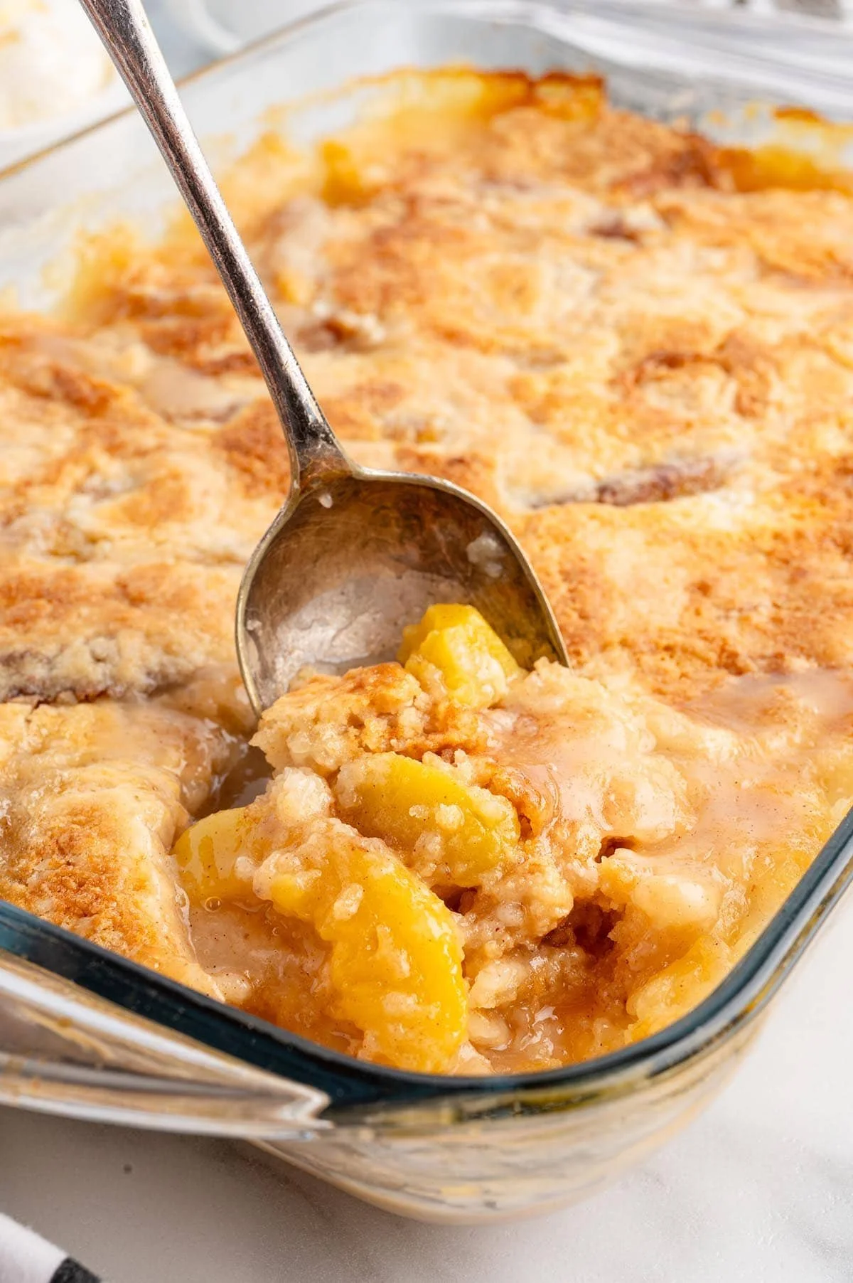 Delicious Peach Dump Cake topped with juicy peaches and crumbly goodness.