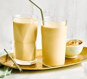 Peanut Butter Banana Protein Smoothie in a glass, topped with banana slices.