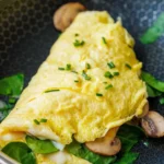 Delicious perfect omelette served with fresh herbs and vegetables.