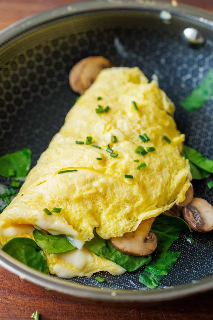 Delicious perfect omelette served with fresh herbs and vegetables.
