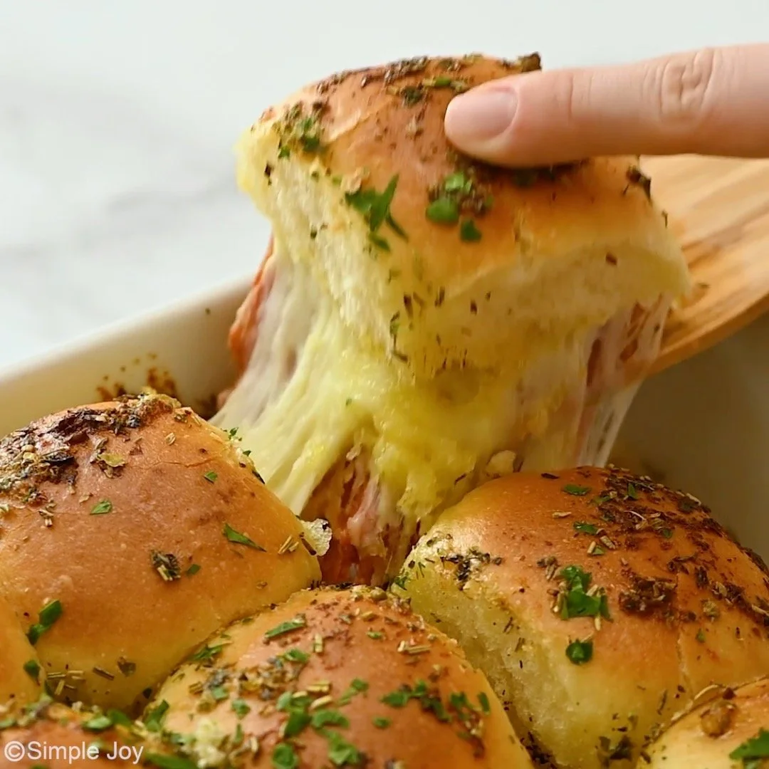 Delicious pizza sliders served on a platter with toppings and condiments.
