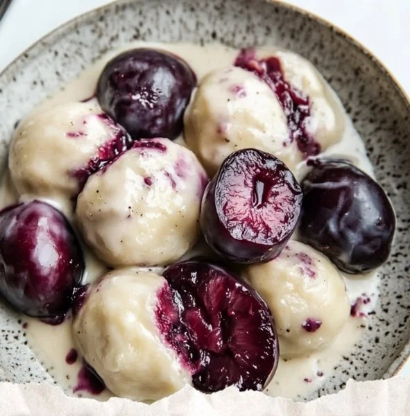A plate of Polish plum dumplings with a sprinkle of sugar