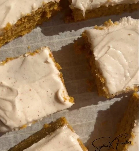 Delicious pumpkin bars with cream cheese frosting on a rustic table
