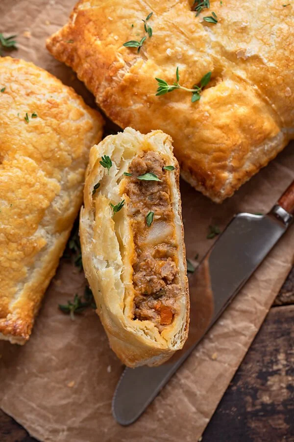 A plate of freshly baked savory hand pies filled with vegetables and meat.