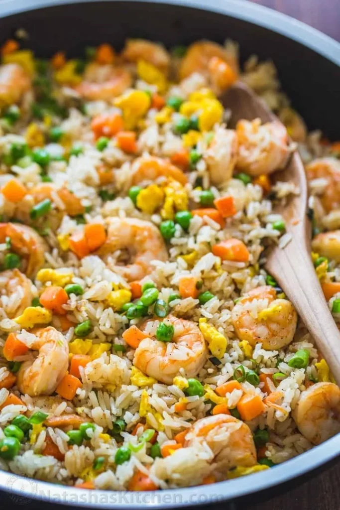 Plate of flavorful shrimp fried rice with vegetables and seasonings