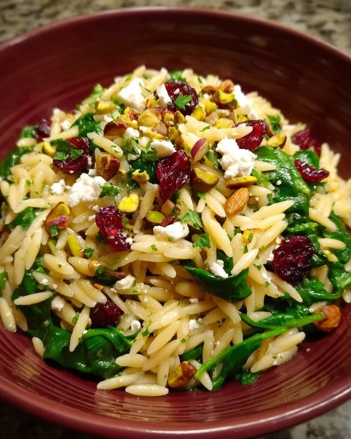 Spinach Orzo Salad with cranberries and pistachios in a bowl.