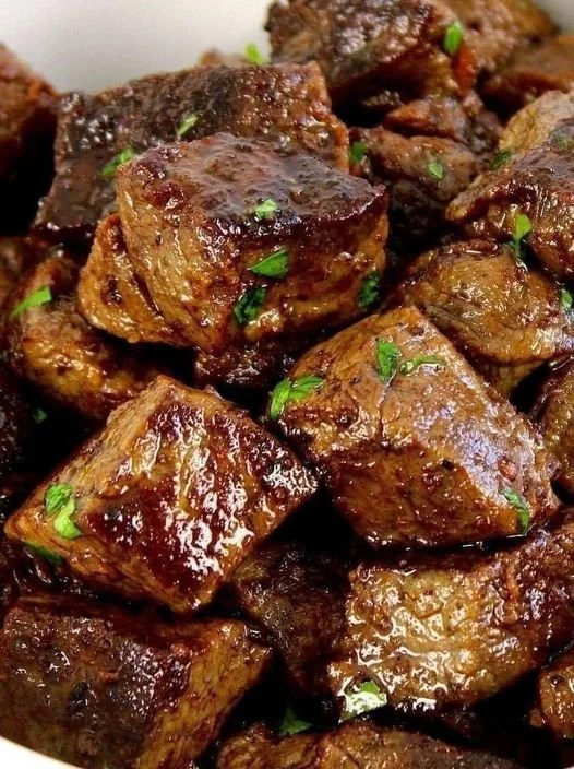 Delicious steak bites topped with garlic butter on a plate