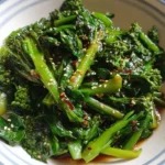 Delicious stir-fried kale rabe topped with ginger soy sauce in a serving bowl.
