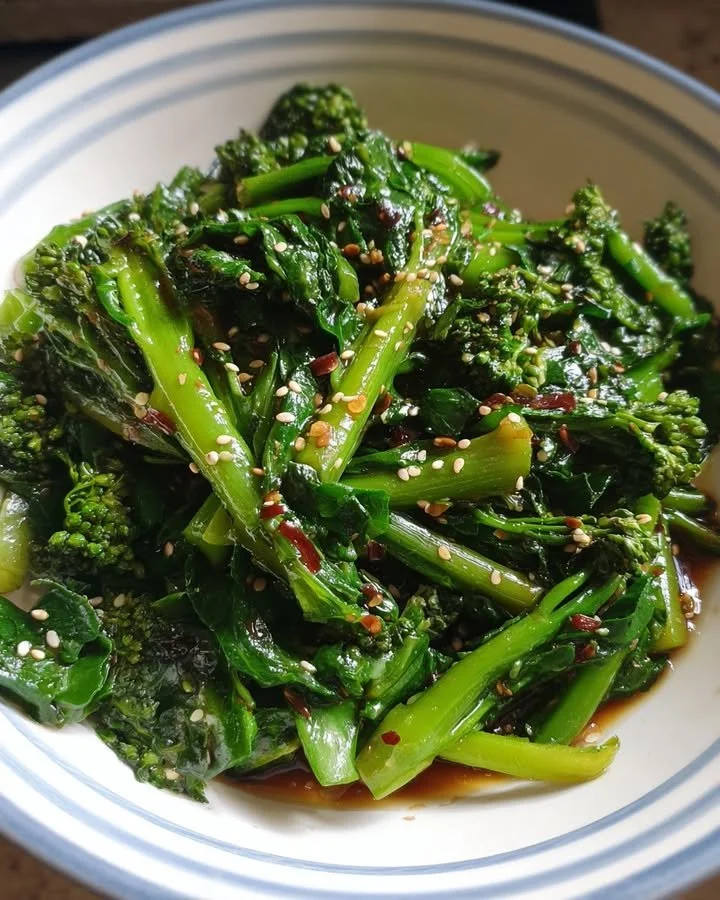 Delicious stir-fried kale rabe topped with ginger soy sauce in a serving bowl.
