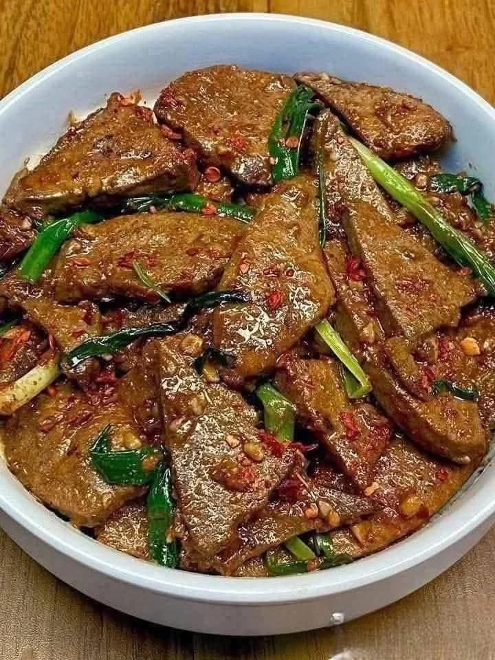 Stir fry pork liver dish garnished with vegetables and herbs