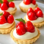 Strawberry cream tartlets with fresh strawberries and cream filling on a plate