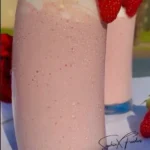 Delicious strawberry milkshake topped with whipped cream and fresh strawberries
