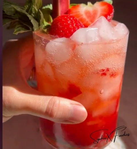 Strawberry Rhubarb Mojito served in a glass with mint leaves and berries
