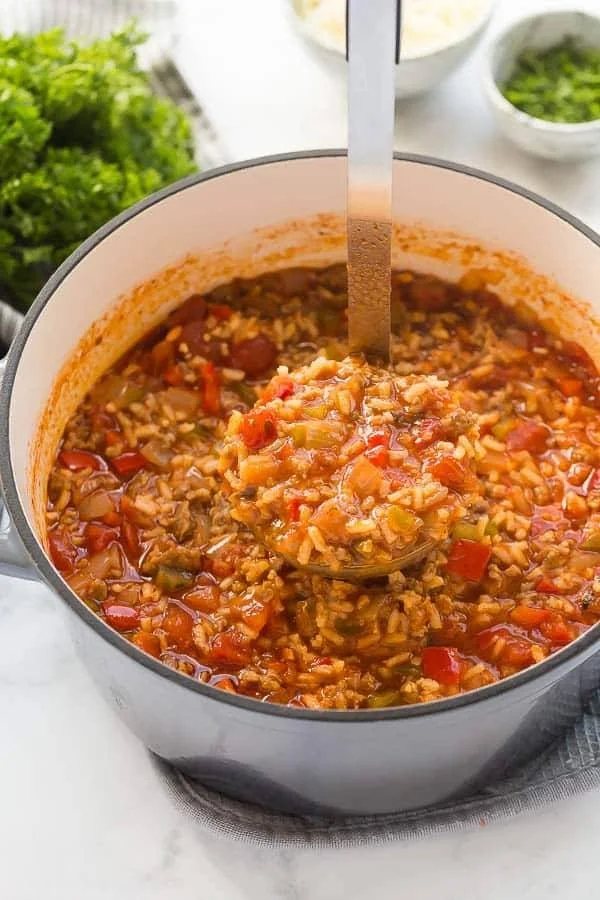 Bowl of delicious stuffed bell pepper soup garnished with fresh herbs.
