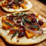 Sweet potato flatbread topped with sage, caramelized onions, and cranberry sauce