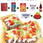 Delicious taco pizza topped with lettuce, cheese, and taco seasonings