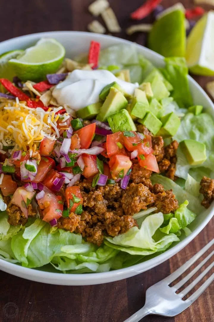 Vibrant taco salad topped with fresh vegetables, cheese, and tortilla chips.