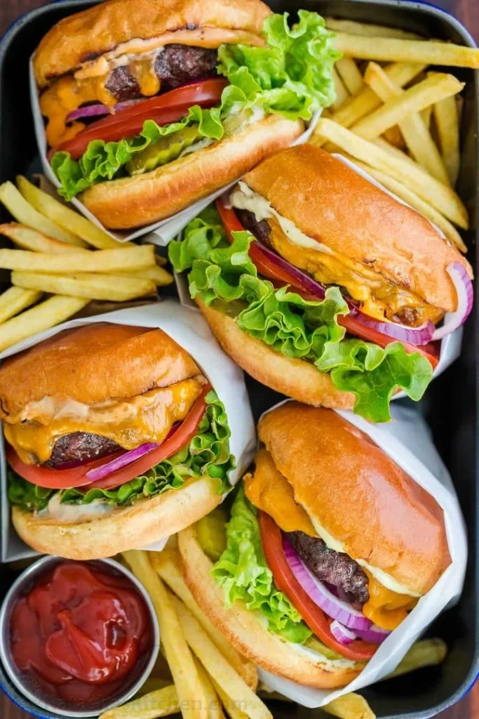 Juicy ultimate hamburger ready for grilling with fresh toppings.