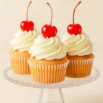 Delicious vanilla cupcakes with a cherry on top, perfect for celebrations