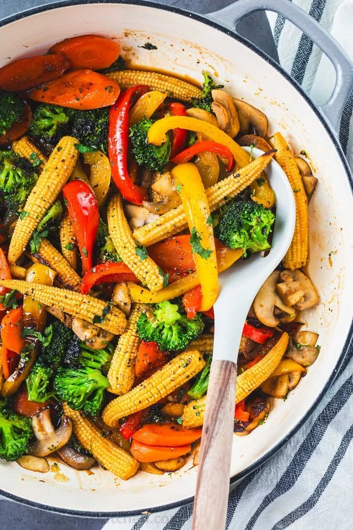 Colorful vegetable stir-fry with fresh veggies and sauce in a pan.