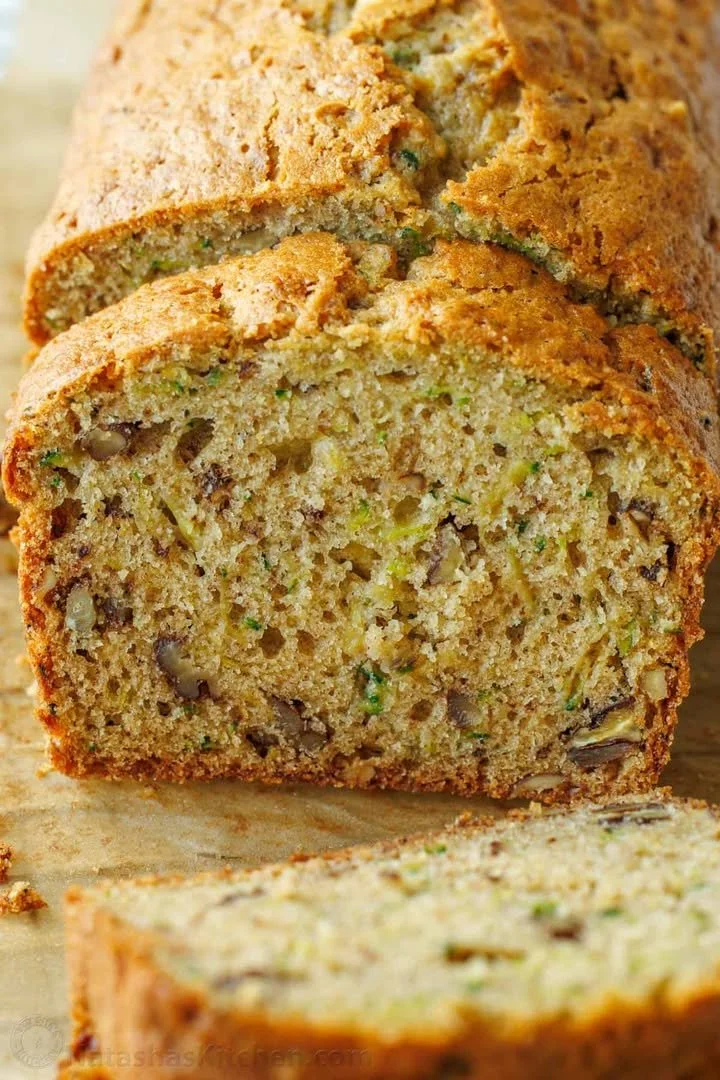 Homemade zucchini bread with fresh zucchini slices on a wooden board
