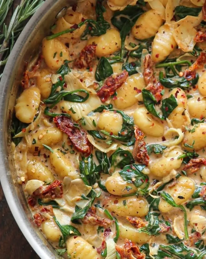 Creamy Tuscan Gnocchi served in a bowl with herbs and vegetables