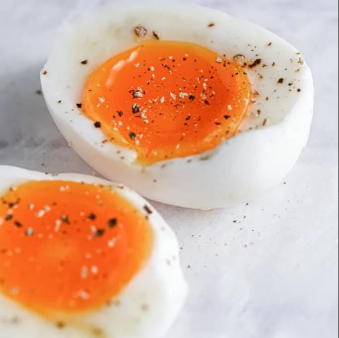 Air fryer soft-boiled eggs with creamy yolks and tender whites on a plate.