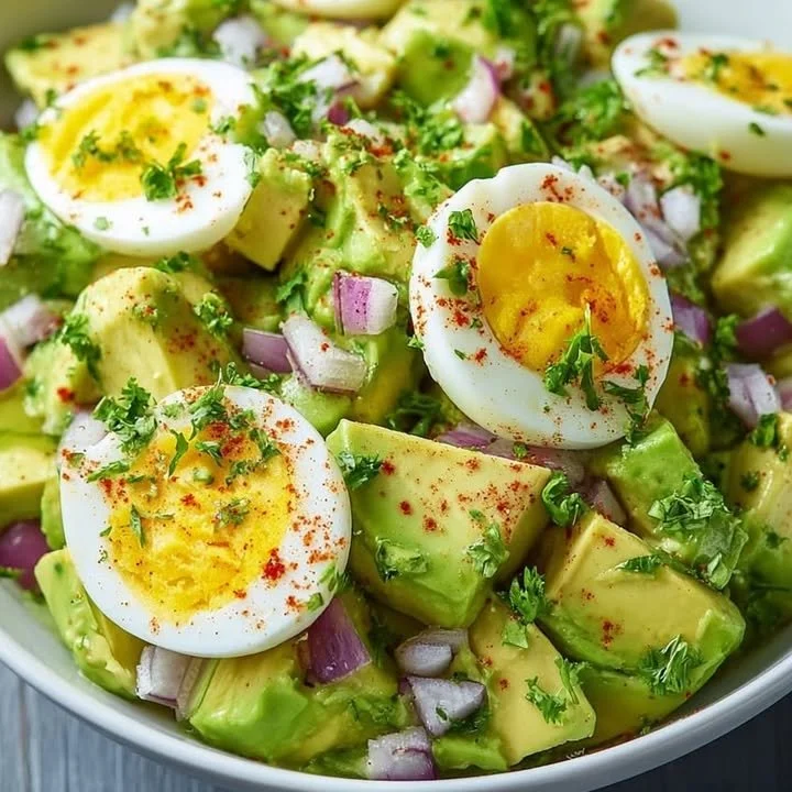 Delicious avocado egg salad served in a bowl with fresh ingredients.