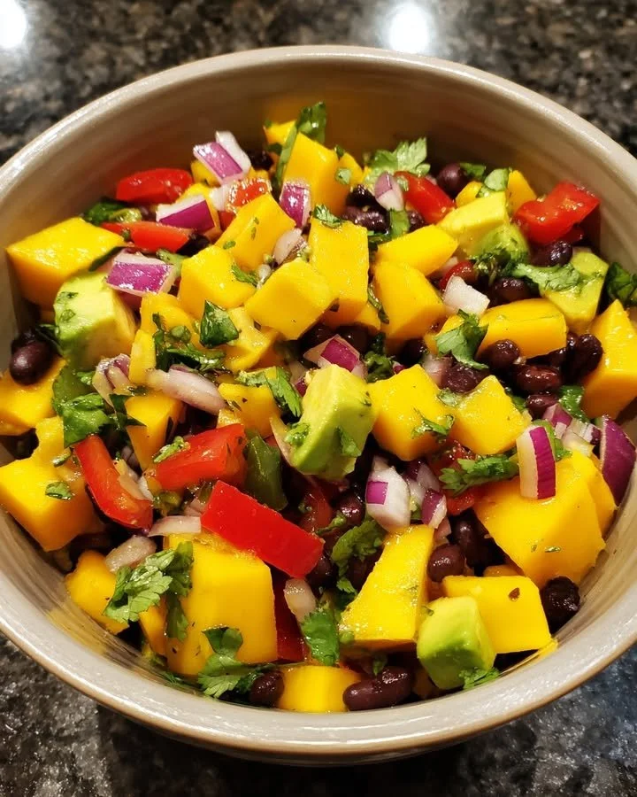 Colorful Avocado & Mango Black Bean Salad served in a bowl with fresh ingredients
