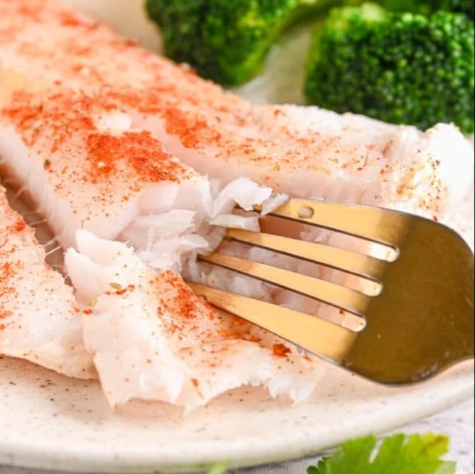 Delicious baked cod fillets garnished with herbs and lemon slices