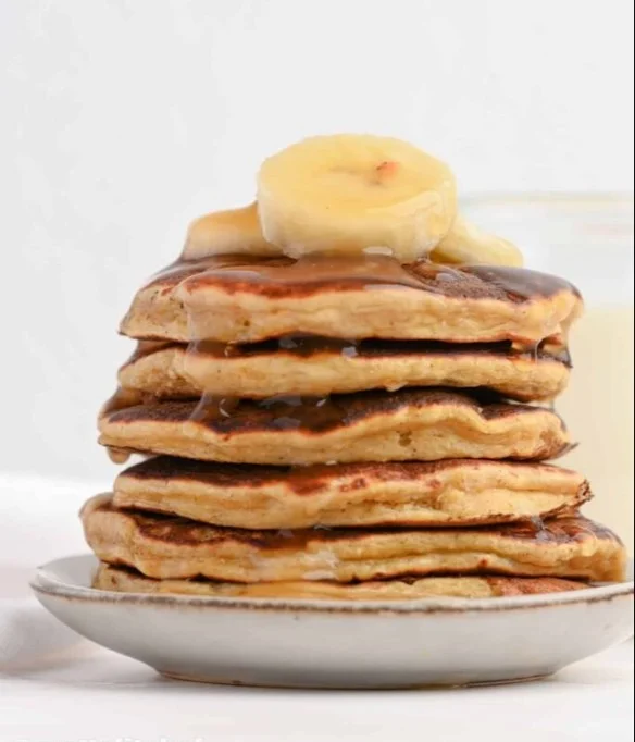 Delicious banana protein pancakes served with fresh fruit and syrup