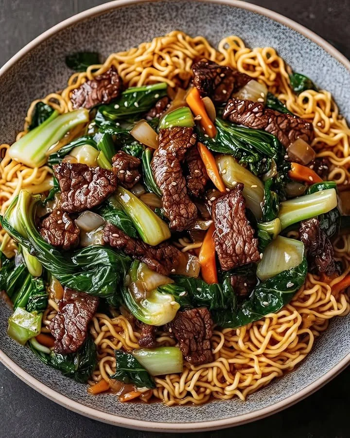 Beef stir-fry noodles served in a bowl with colorful vegetables