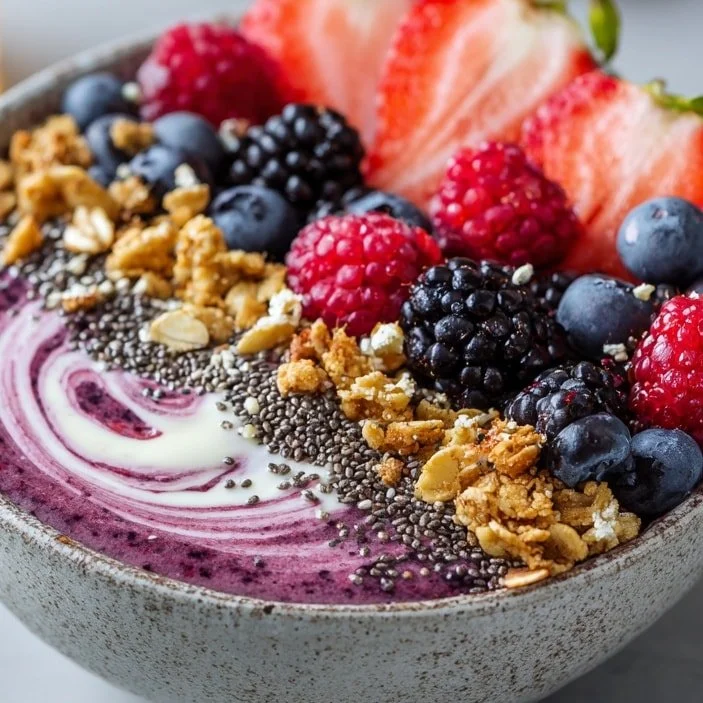 Berry Acai Smoothie Bowl topped with fresh fruits and granola.