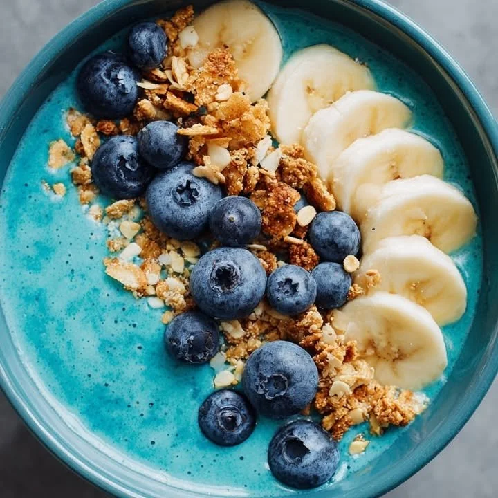 Delicious blue smoothie bowl topped with fresh fruits and nuts