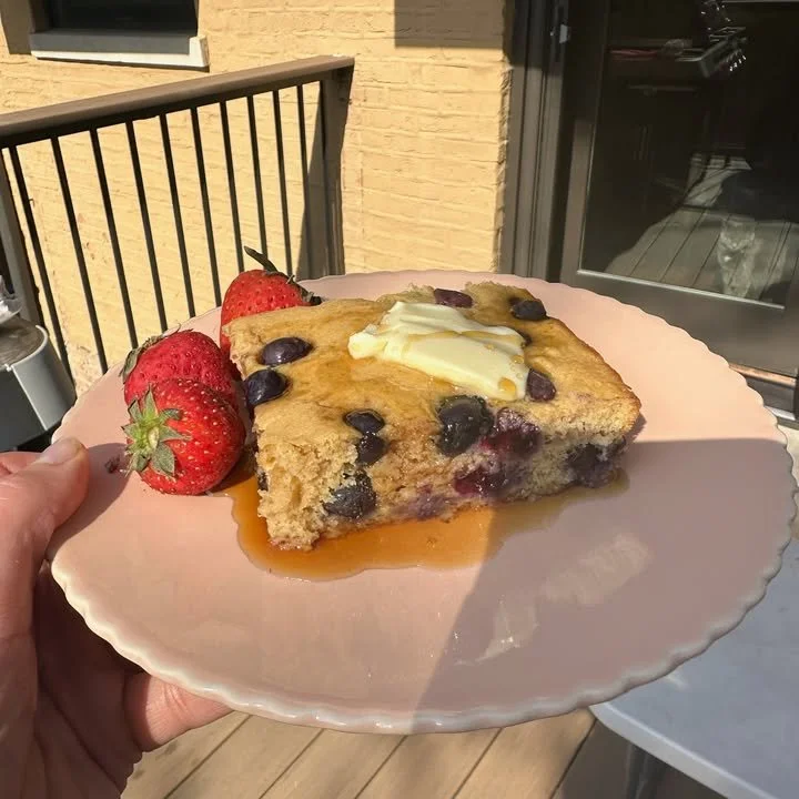 Blueberry protein pancake breakfast cake topped with fresh blueberries and syrup