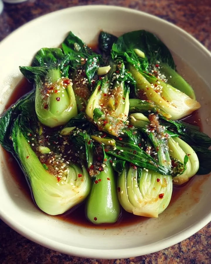 Bok Choy with Garlic Sauce served in a bowl garnished with sesame seeds