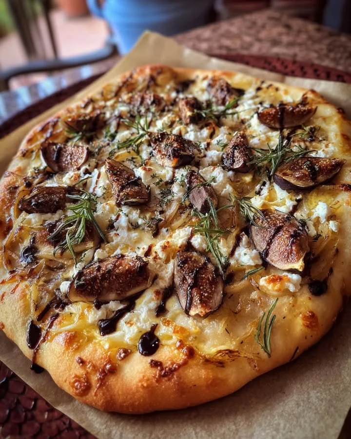 Caramelized onion and fig flatbread topped with rosemary, a gourmet appetizer.