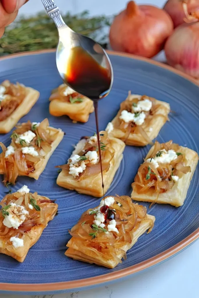 Caramelized onion and goat cheese puff pastry bites topped with balsamic glaze