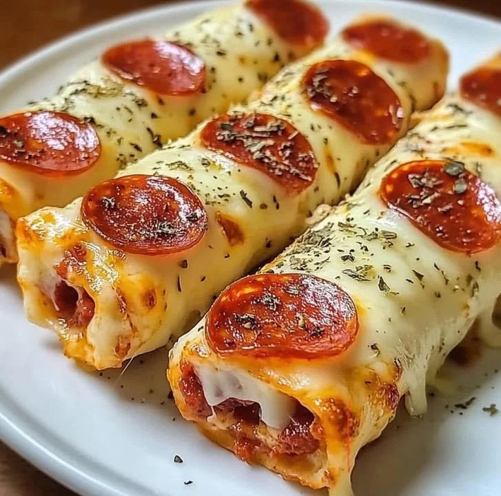 Cheesy Pepperoni Pizza Roll-Ups served on a plate with dipping sauce.