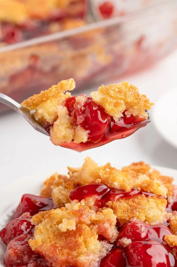 Delicious cherry dump cake with a golden topping, served in a bowl.