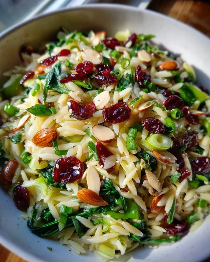 Choy and Orzo Salad with cranberries and almonds in a vibrant bowl