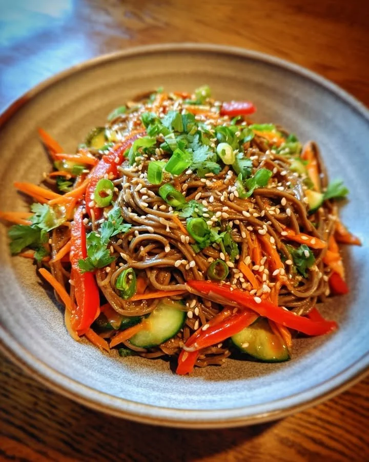 Cold soba noodle salad garnished with vegetables and sesame dressing